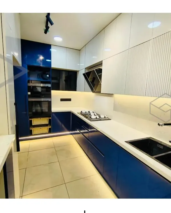 This U-shaped modular kitchen combines bold blue acrylic cabinets with crisp white overheads for a striking, modern look. I focused on an efficient layout, integrating appliances seamlessly and using under-cabinet LED lighting to brighten the workspace.