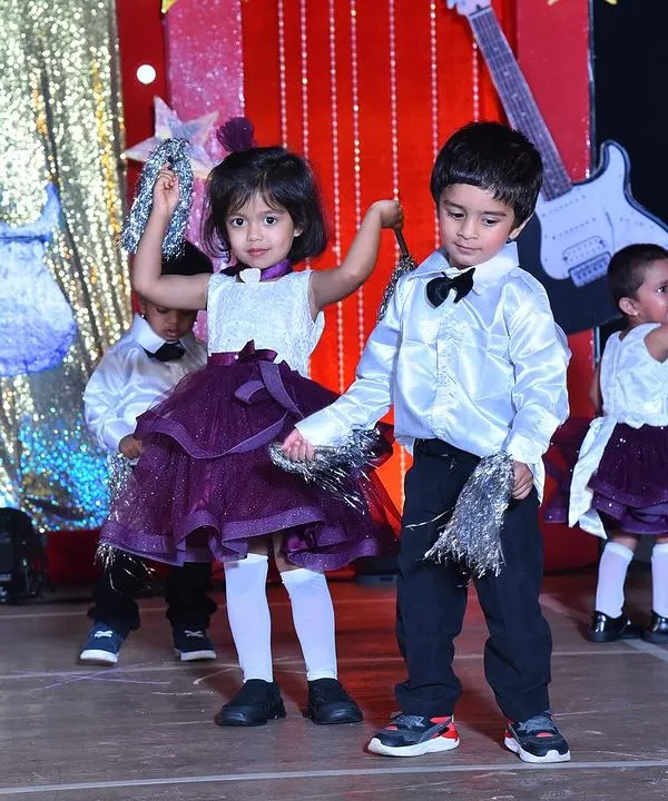 Capturing the fun of a rock-and-roll themed performance, with boys in smart bow ties and girls in stylish purple skirts.