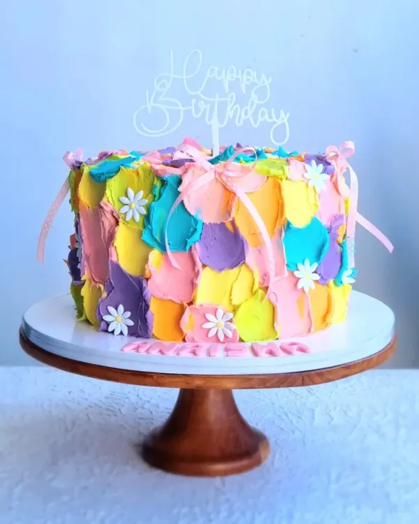 A colorful buttercream cake with a painted, textured effect. I teach how to use a palette knife to apply different colors of buttercream for this artistic, abstract look.