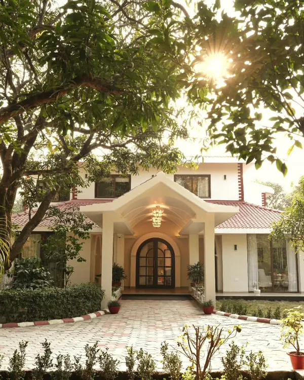 For this beautiful homestay in Dehradun, I designed the structure to feel like a natural extension of its lush surroundings. The facade and portico create a welcoming embrace, while large windows frame the landscape, blurring the line between inside and out.