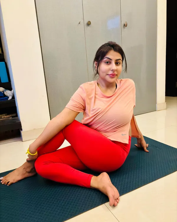 A student holds Ardha Matsyendrasana (Half Lord of the Fishes Pose) during a personal yoga session at her home. This seated twist is excellent for improving spinal mobility, aiding digestion, and calming the nervous system.