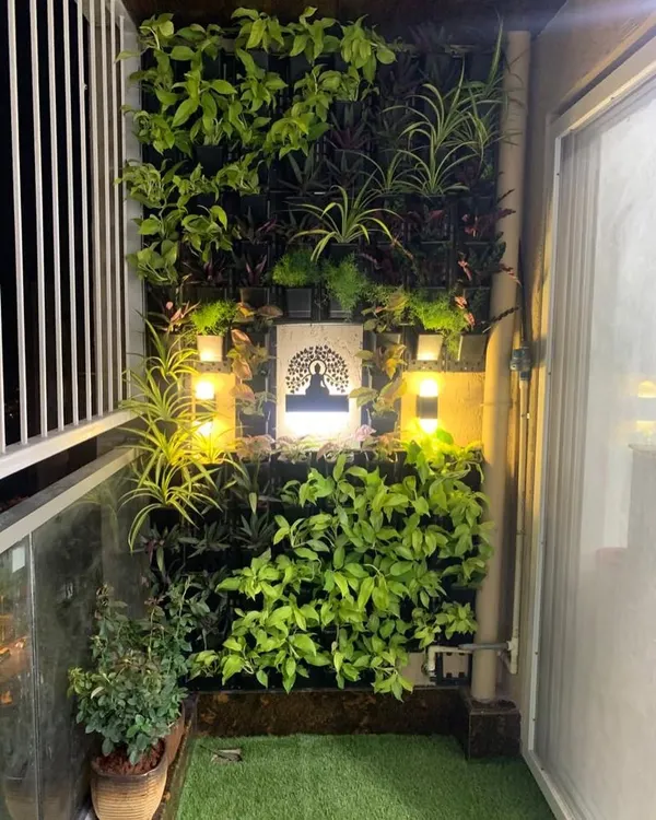 A closer look at a custom balcony vertical garden at night. The warm, strategically placed lighting highlights the plant textures and the central art piece, proving that your garden can be enjoyed day and night.