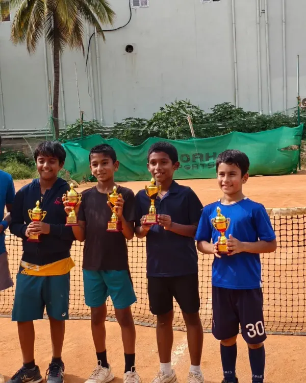 A group of our upcoming champions proudly displaying their trophies on our clay courts. This photo captures the joy and success of Jaideep, Lawan, Amish, and Hamsini after a great tournament performance.