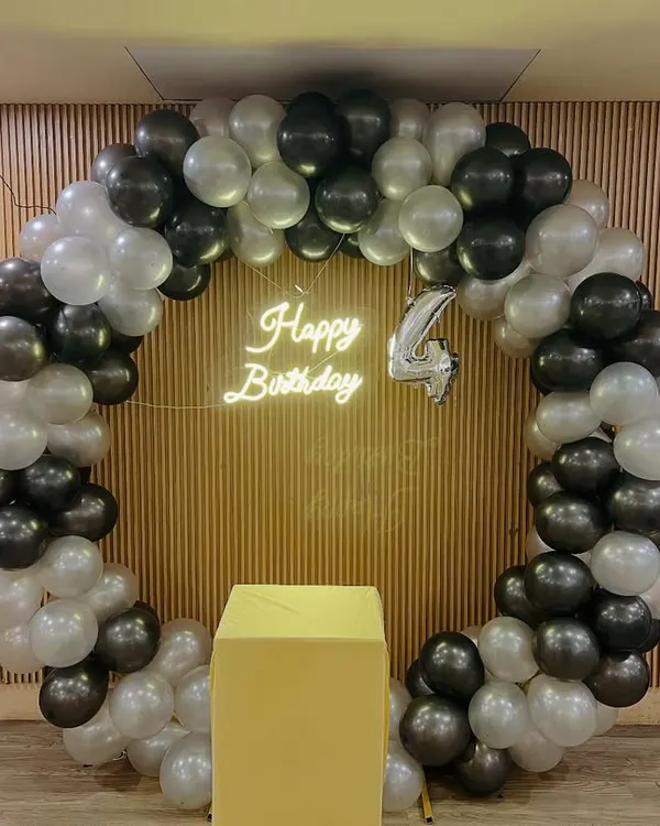 This is my specialty, a full circular balloon arch with a custom neon sign. I created this modern black and silver theme for a 4th birthday party, perfect for making a big statement and as a backdrop for cake cutting photos.