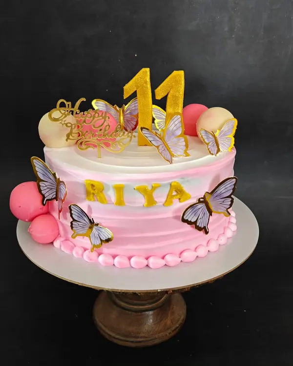 A sweet and simple butterfly cake in shades of pink, perfect for an 11th birthday.