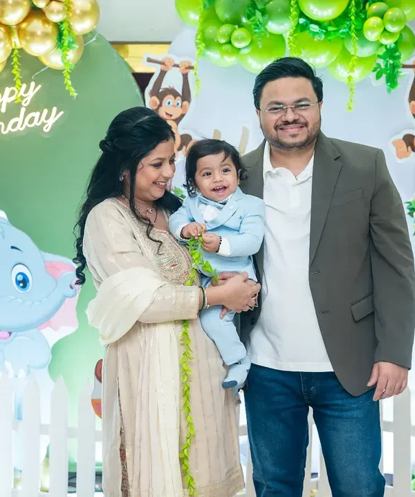 A classic family portrait in front of the birthday decorations. Capturing the whole family together, smiling and happy, is a must-have shot for any first birthday party.