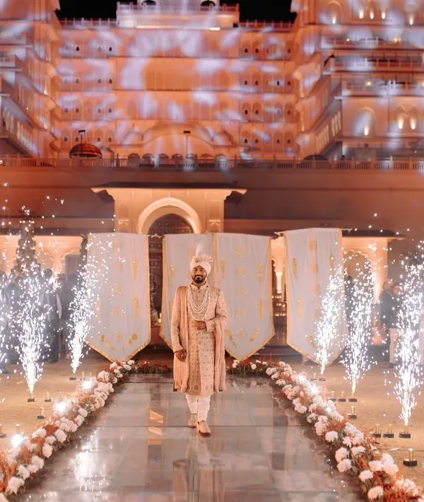 A groom's entry that commands attention. We designed this path with a mirrored walkway, cold pyro fountains, and dramatic projection mapping on the palace, creating a truly grand and heroic entrance.