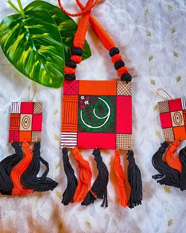 This is another view of my geometric patchwork necklace. The combination of hand-painted fabric, thread tassels, and a vibrant color palette makes it a standout piece of contemporary handcrafted jewelry.