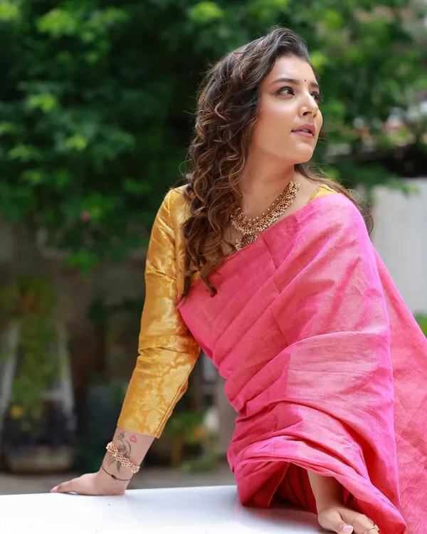 For the brand Ruii.co, I styled this linen saree to create a modern ethnic look. The combination of a bright pink saree with a contrasting gold blouse feels contemporary and chic.