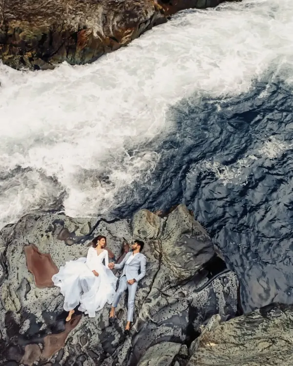An aerial view of a couple finding a quiet moment together amidst the powerful currents of a Kashmir river. This is the kind of grand, cinematic pre-wedding photography we love to create, turning your love story into an epic film.