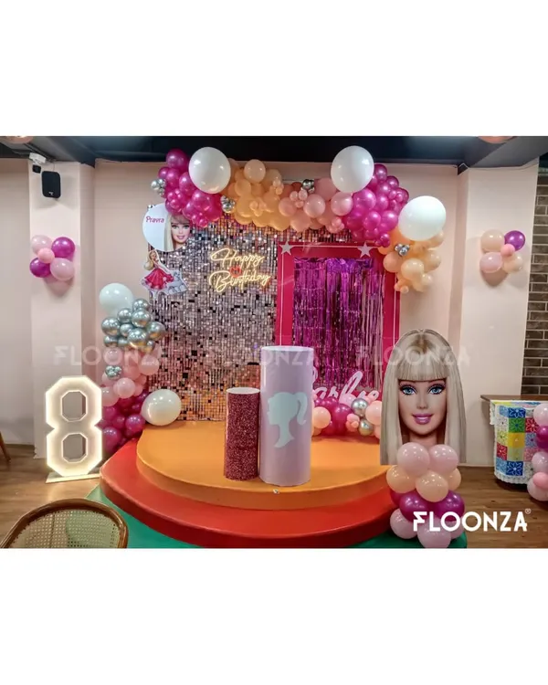 This Barbie-themed stage is perfect for a milestone birthday. I created a glamorous focal point using a silver sequin shimmer wall, a custom neon sign, and a vibrant balloon garland in shades of pink, orange, and white. The setup includes a light-up marquee number '8' and themed pedestals for the cake, making it a complete photo-ready zone.