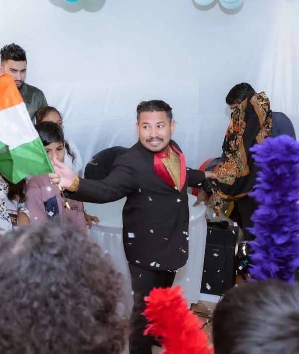 I arrange for top-notch entertainment to keep guests of all ages engaged. Here, a professional magician performs a trick for an amazed audience at a first birthday party.