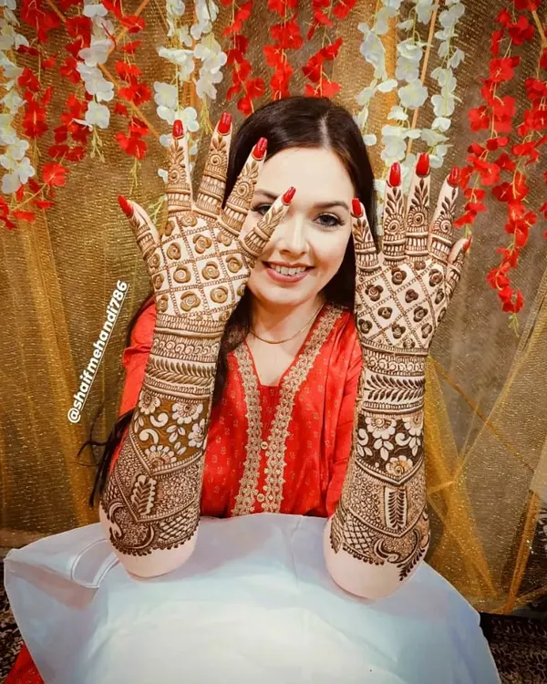 This is what a happy bride looks like. I love creating these full-coverage back-hand designs that look stunning in photos. This particular pattern uses a classic jaali or net design, which is a favorite for many brides.