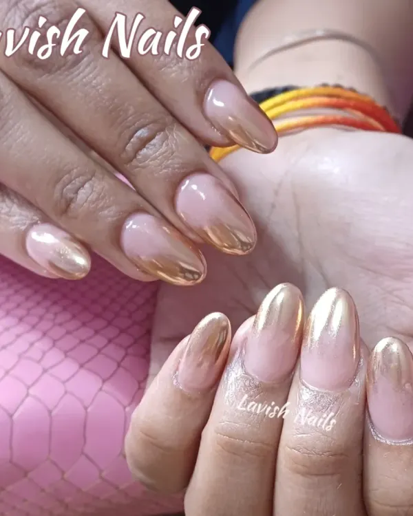 A stunning gold chrome ombre on almond-shaped nails, fading from a brilliant metallic into a soft nude base.