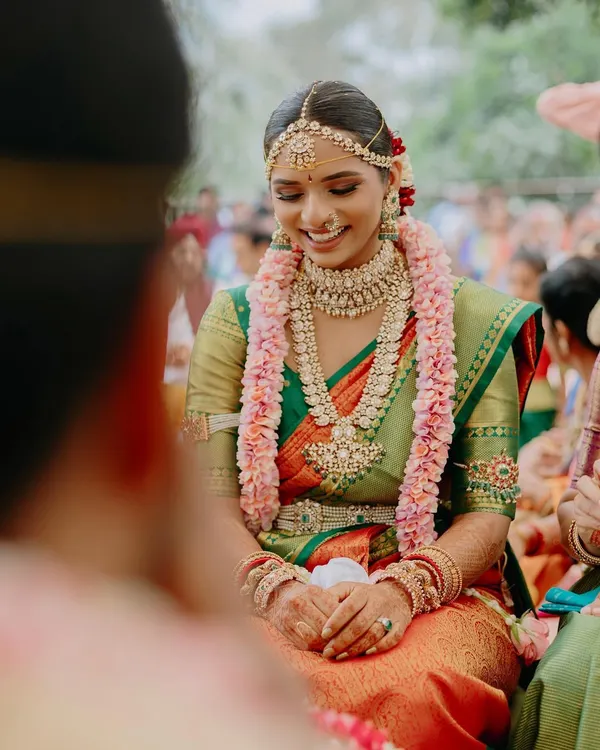 The joy of a South Indian wedding ceremony. Meghana’s smile is radiant as she participates in the rituals. Her makeup is traditional, with an emphasis on the eyes and a flawless skin finish.