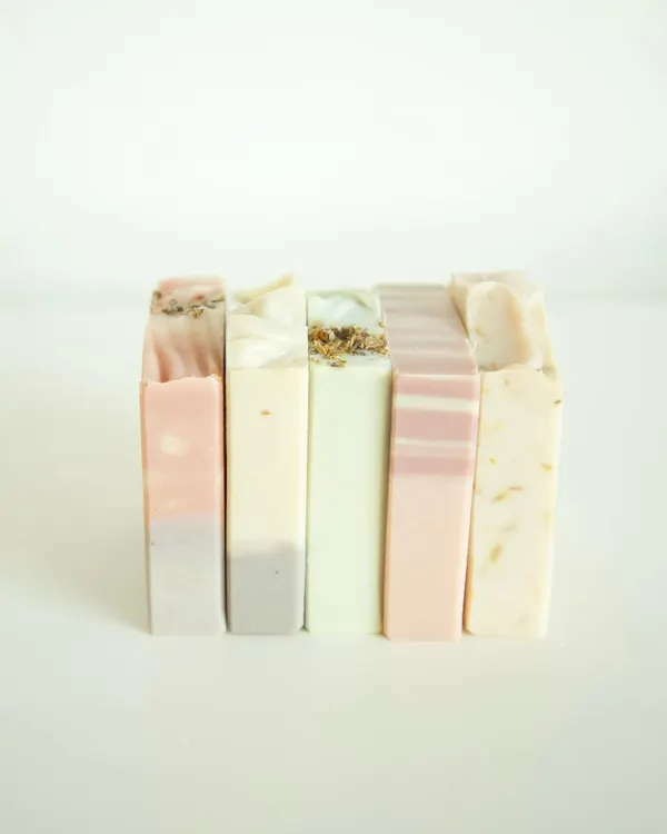 A beautiful stack of my soaps, showcasing the variety of natural colors and textures. From left to right: Lavender Patchouli, Neroli Patchouli, Eucalyptus Tea Tree & Rosemary, Flower Market, and Jasmine Calendula.