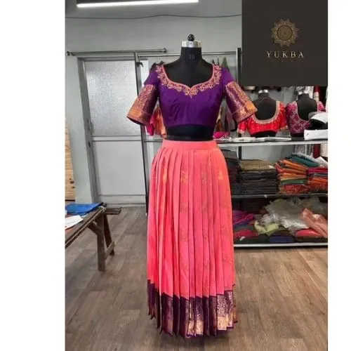 A full view of a beautiful half-saree ensemble. The custom-embroidered purple blouse is paired with a contrasting pleated pink skirt, creating a vibrant and traditional look.