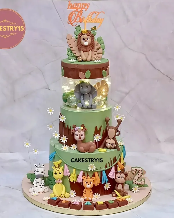 This four-tier jungle adventure cake is a true showstopper, perfect for a grand celebration. It features a rotating top tier with a crowned lion, a light-up spacer, and a delightful assembly of handcrafted fondant animals including an elephant, giraffe, tiger, and monkeys.