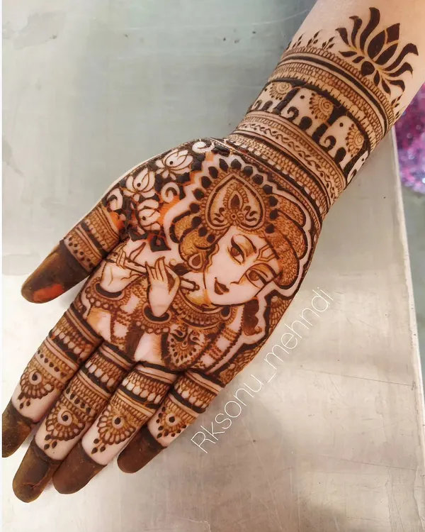 A stunning portrait of Lord Krishna playing his flute, intricately detailed to fit on the palm of the hand. This design is a beautiful way to carry a symbol of divine love and music.