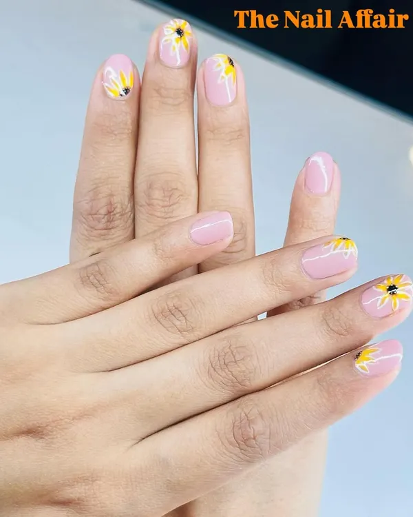 A cheerful sunflower design painted on a soft pink base. This is a perfect way to bring a little bit of sunshine to your manicure.