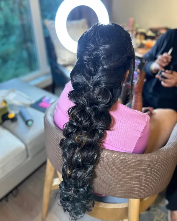 A close-up of a voluminous and textured bridal braid. This modern take on a classic style is perfect for a sangeet or reception.