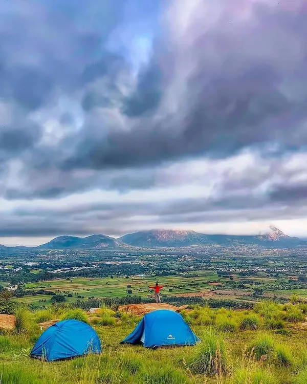 Camping with a view of the rolling landscape near Namma Bengaluru. This spot overlooks the plains and distant hills, including the famous Nandi Hills, offering a sense of scale and freedom.