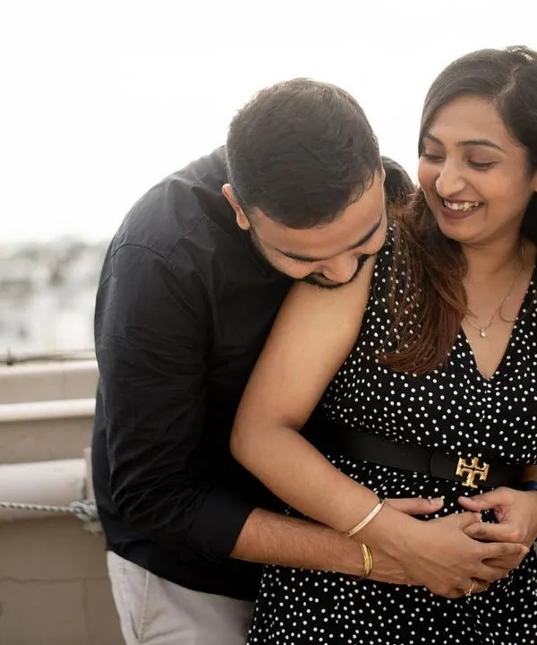 The pure joy of a pregnancy announcement. This candid shot on a rooftop captures the couple's laughter and excitement. These early-stage sessions are all about celebrating the beginning of a new chapter.