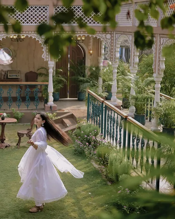 A beautiful solo portrait of the bride, capturing the graceful movement of her all-white outfit against the backdrop of a heritage location. These twirling shots are always full of life.