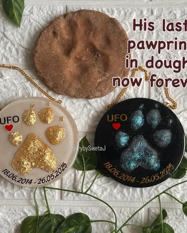 This piece is a tribute to a beloved dog named UFO. His mom sent me his last pawprint, pressed into dough. I created two memorial plaques from it: one with a celestial, shimmery design and another in brilliant gold leaf, with the original dough print shown alongside.