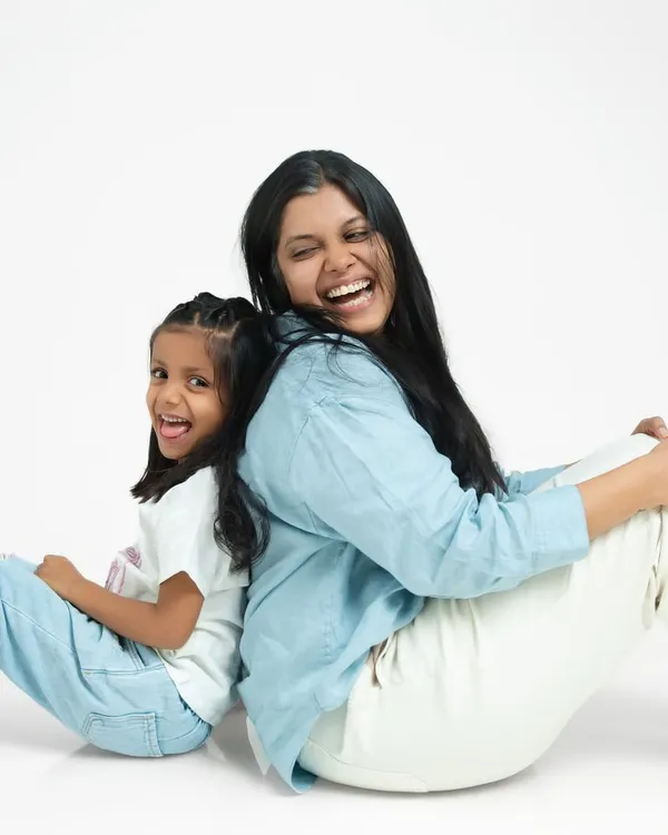 The pure joy of a mother and daughter laughing together, back to back. My studio family portraits are clean and simple, keeping the focus entirely on your connection and emotion.