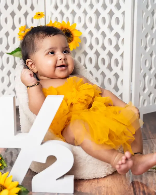 Halfway to one. This six-month sitter session celebrates a huge milestone with a bright and cheerful sunflower theme, complete with a '1/2' sign.
