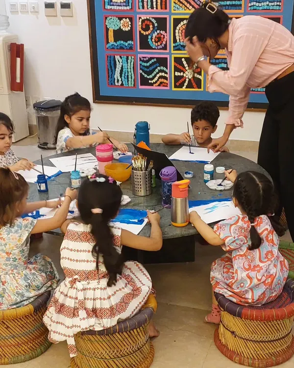 My cutie pie toddlers, busy at work. With focused faces and colorful stools, they are completely absorbed in their painting activity.