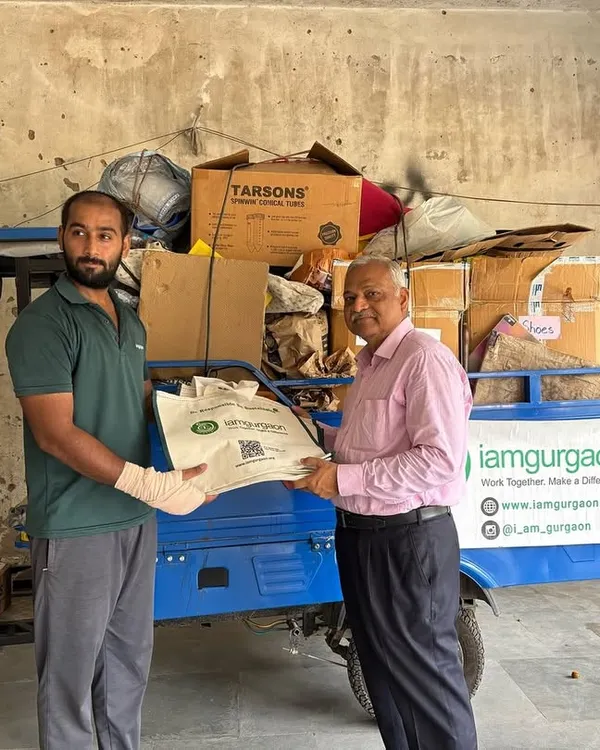 A member of our team receives a bag of sorted dry waste from a resident during a community collection drive. Every contribution, big or small, adds up to a massive collective impact.