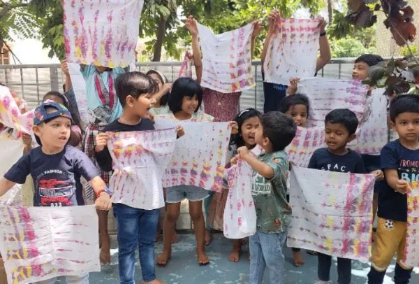 Look what we made! The children proudly display their unique tie-dye creations. This activity is a fantastic way to learn about colors, patterns, and the magic of transformation.