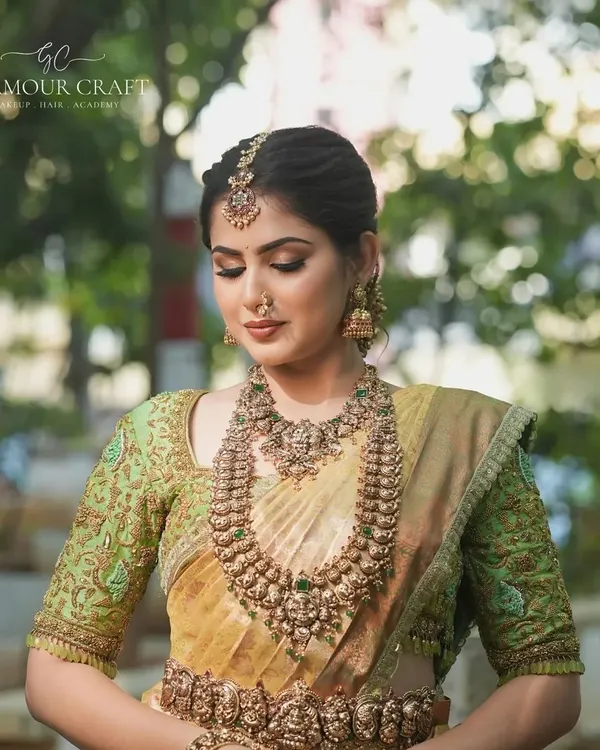 A complete antique-finish bridal set that exudes royalty. The layered necklaces, matching oddiyanam (waist belt), and jhumkas are crafted to make you feel like a queen on your wedding day.
