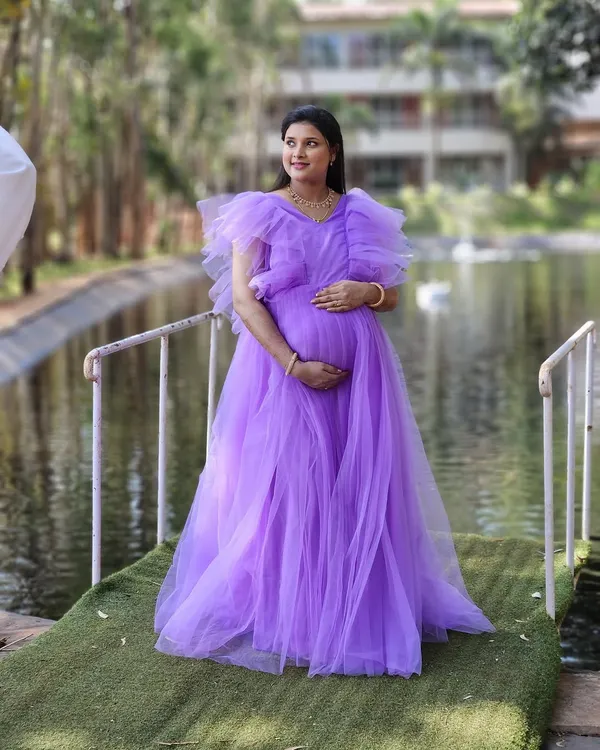A beautiful lavender ruffled gown, perfect for a dreamy and romantic maternity shoot. The color is soft, and the tulle fabric creates a voluminous, princess-like silhouette.
