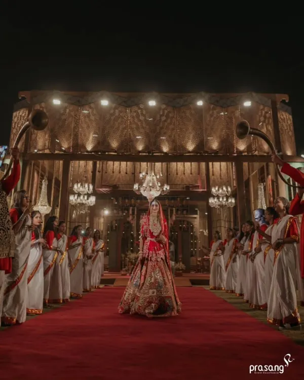 The bride's entrance is a pivotal moment. I design a grand processional, complete with a regal red carpet, traditional musicians, and dramatic lighting, to ensure her walk towards the mandap is as majestic and memorable as she deserves.