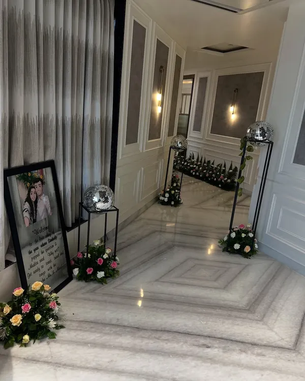 Even the most intimate celebrations deserve grand details. We transformed this home's hallway for a pre-wedding function with elegant floral arrangements, personalized welcome signs, and subtle touches like disco balls for a hint of glamour.