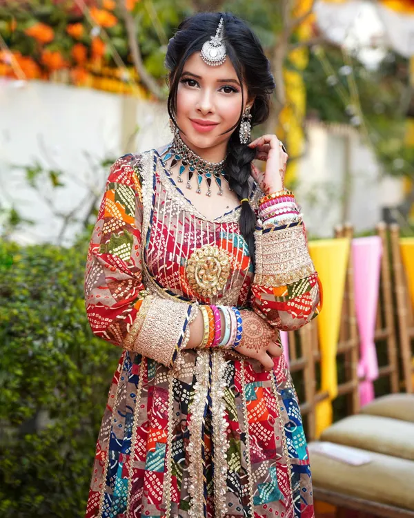 A full view of this stunning multi-colored Banjara-inspired Anarkali. It's a perfect example of a bold and beautiful outfit for a Mehendi ceremony, styled with layered necklaces and colorful bangles.