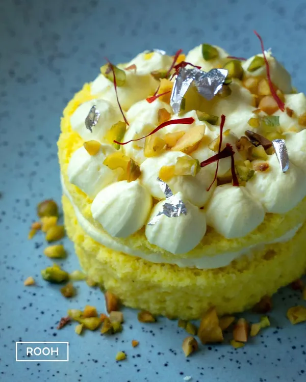 Our Rasmalai Cheesecake, a true fusion masterpiece. This dessert features layers of saffron-infused sponge and creamy cheesecake, topped with pistachios and delicate silver leaf.