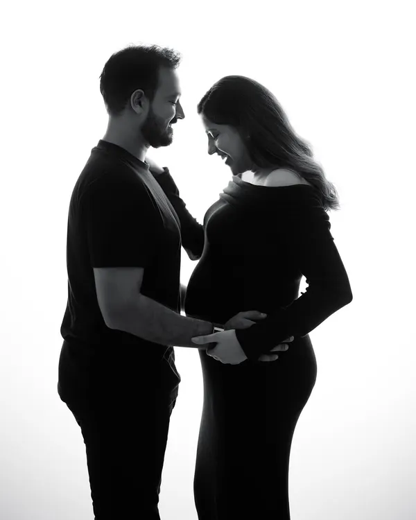 A simple silhouette in black and white can tell the most powerful story. This image captures the shared joy and anticipation between two people about to become parents.