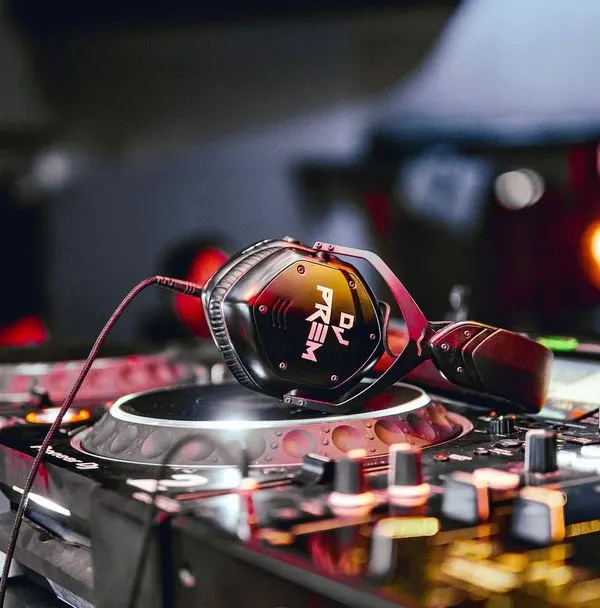 An artistic shot of my custom headphones resting on a Pioneer DJ turntable. This represents my commitment to using high-quality, reliable equipment for every performance.