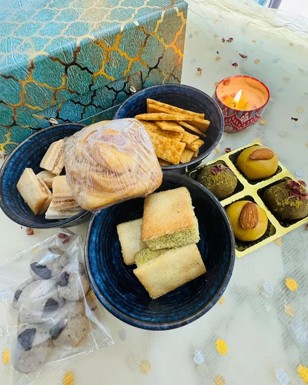 This is my premium 'Swaad-e-Diwali' gift hamper, a true feast for the senses. It includes my Nankhatai Pistachio Sandwich, Brown Butter Shakarpara, Vada Pav Crackers, Besan Laddoo, Pistachio Mafroukeh, and a Marbled Biscoff Cube Cake.