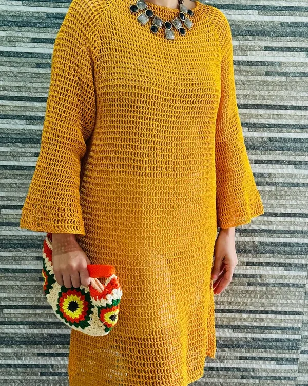 This is my handmade mustard bell sleeve dress, a piece I'm incredibly proud of. It's designed with a breathable open-weave stitch, making it perfect as a statement piece for a sunny day out or as a stylish beach cover-up.