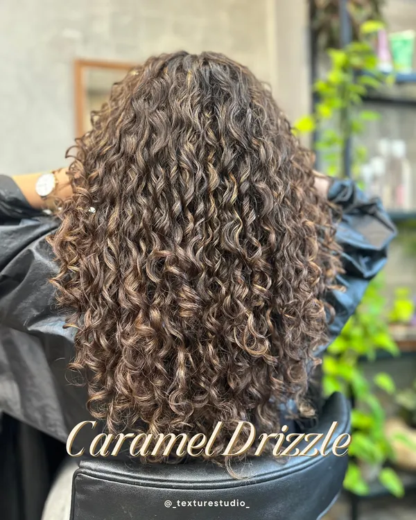 This is the Caramel Drizzle look, a perfect example of how I add dimension to curls with custom color. I focused on placing honey and caramel tones to catch the light and make each curl pop, all while keeping the hair healthy and hydrated.