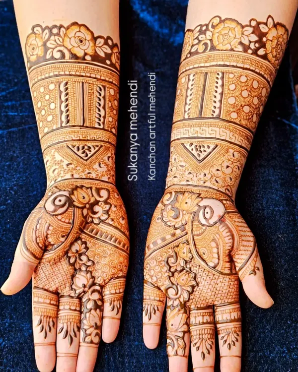 A full bridal look featuring stunning peacock figures and detailed floral work. The design extends up the arm with beautiful bands and patterns, perfect for a grand wedding celebration.