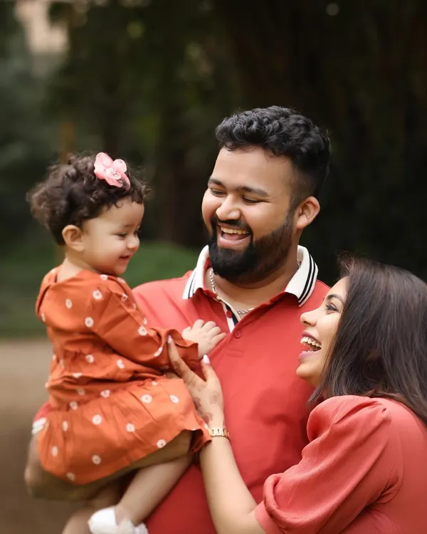 The sound of pure joy. This candid photo of a family sharing a laugh in a beautiful garden setting is what outdoor sessions are all about. It's real, it's full of love, and it's a memory frozen in time.