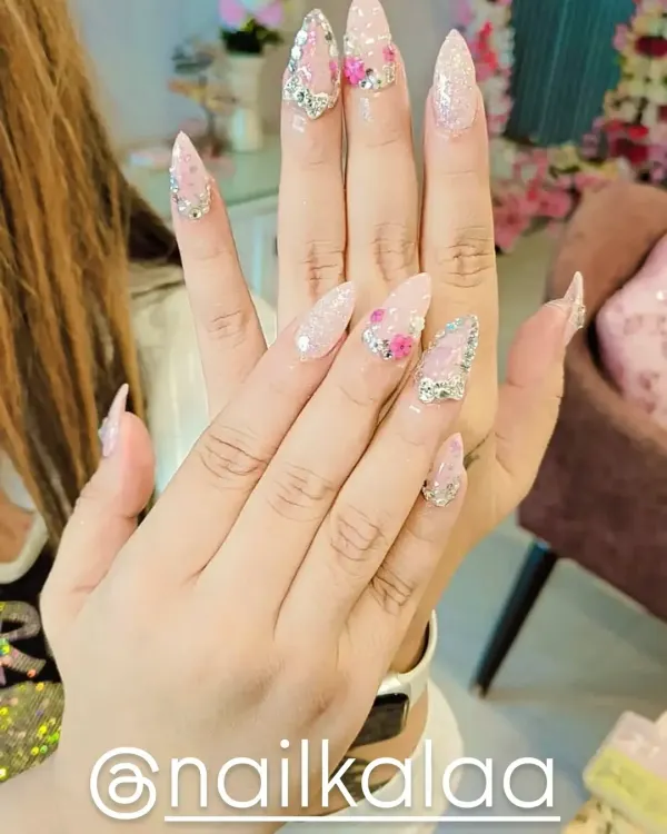 This is one of my signature dramatic looks, perfect for when you want your nails to be the center of attention. It features long stiletto extensions with a base of sparkling pink glitter, accented with delicate 3D flowers and precisely placed rhinestones for maximum impact.