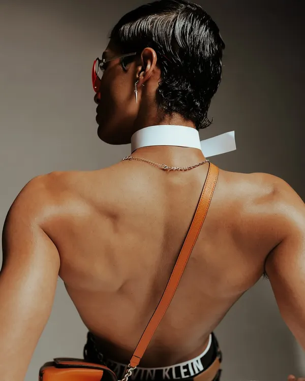 A detail-oriented shot for Calvin Klein, focusing on the product and the model's form. The angle highlights the brand's signature waistband and the texture of the accessories.