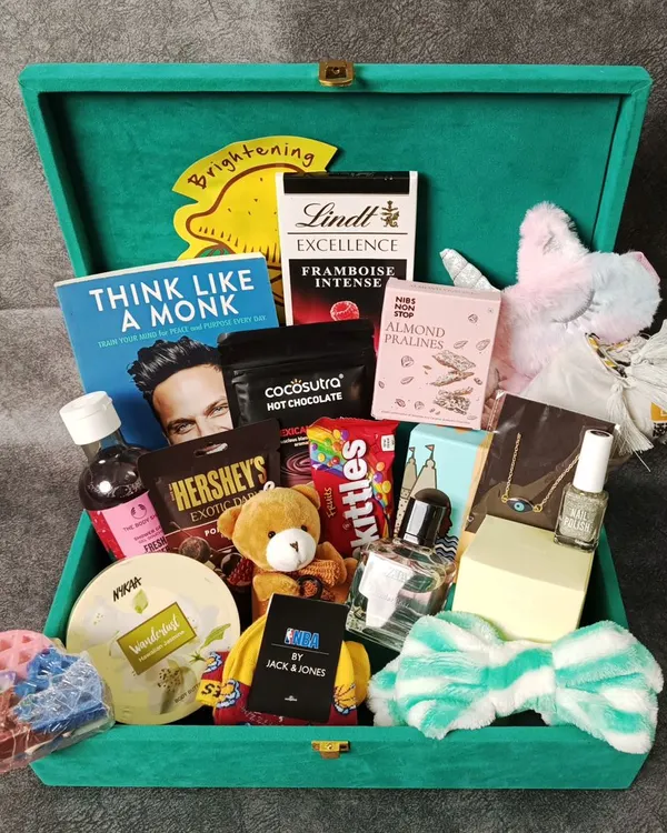 A luxurious hamper packed and ready to be sent to Mumbai. This large green velvet box is filled to the brim with books, chocolates, skincare, and more.